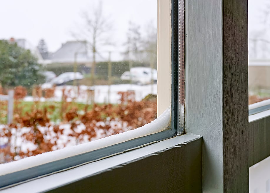 Double-glazed windows with accumulated snow on its edges. — Harry Wedzinga // Shutterstock