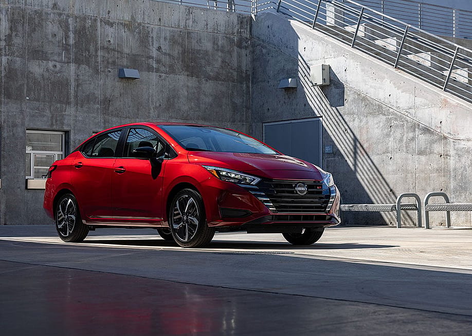 A red 2025 Nissan Versa parked in a concrete lot. — Nissan