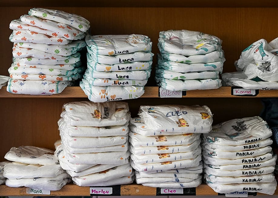 A daycare center's shelf with stacks of various children's diapers with their names written on them. — Jens Kalaene // picture alliance via Getty Images