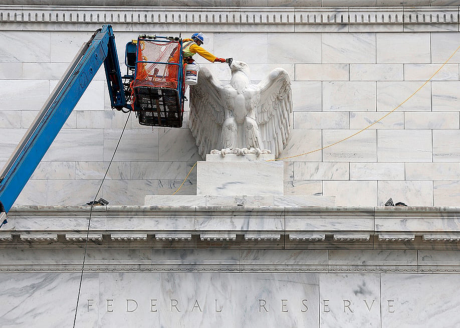 Workers paint an eagle statue on the Marriner S. Eccles Federal Reserve Board Building in Washington, DC. — Kevin Dietsch // Getty Images