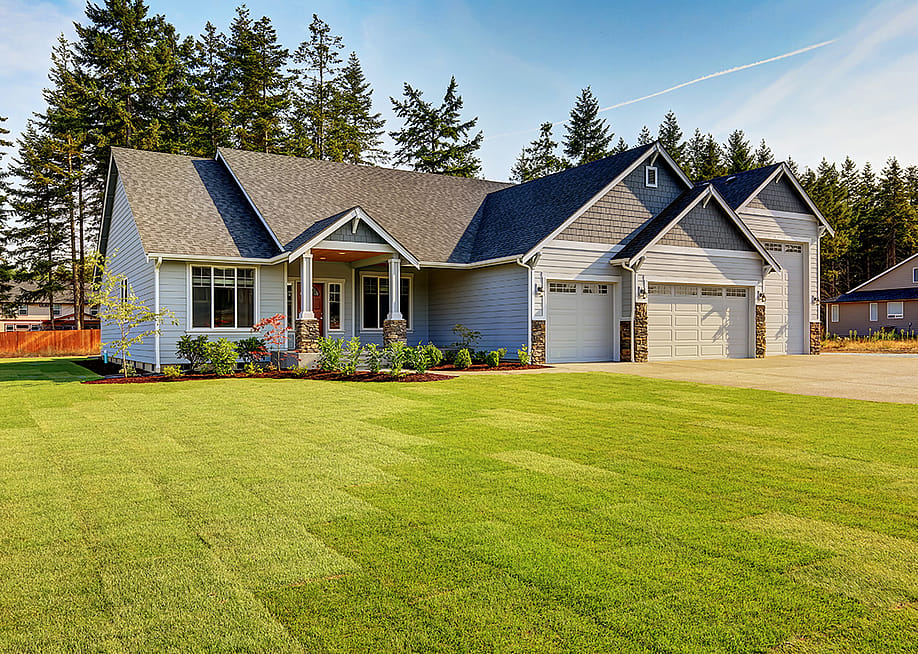 A modern, luxury home with a wide lawn in a Northwestern residential neighborhood in the US. — Artazum // Shutterstock