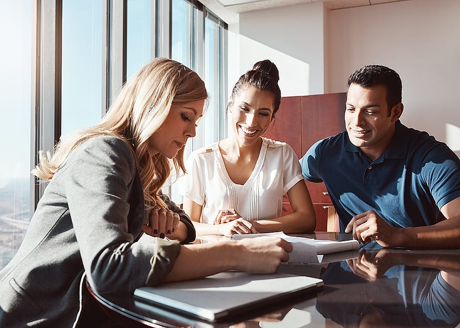 A couple engaging in a discussion with a financial advisor. — PeopleImages // Shutterstock