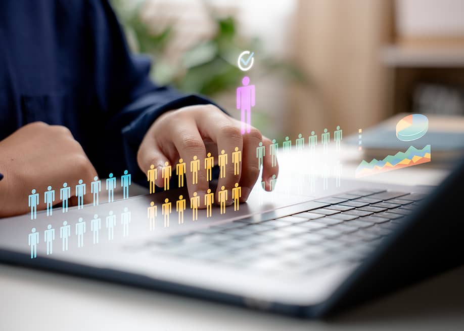 Concept of HR recruitment showing digital human figures illustrated over a businessperson using a laptop. — CL STOCK // Shutterstock