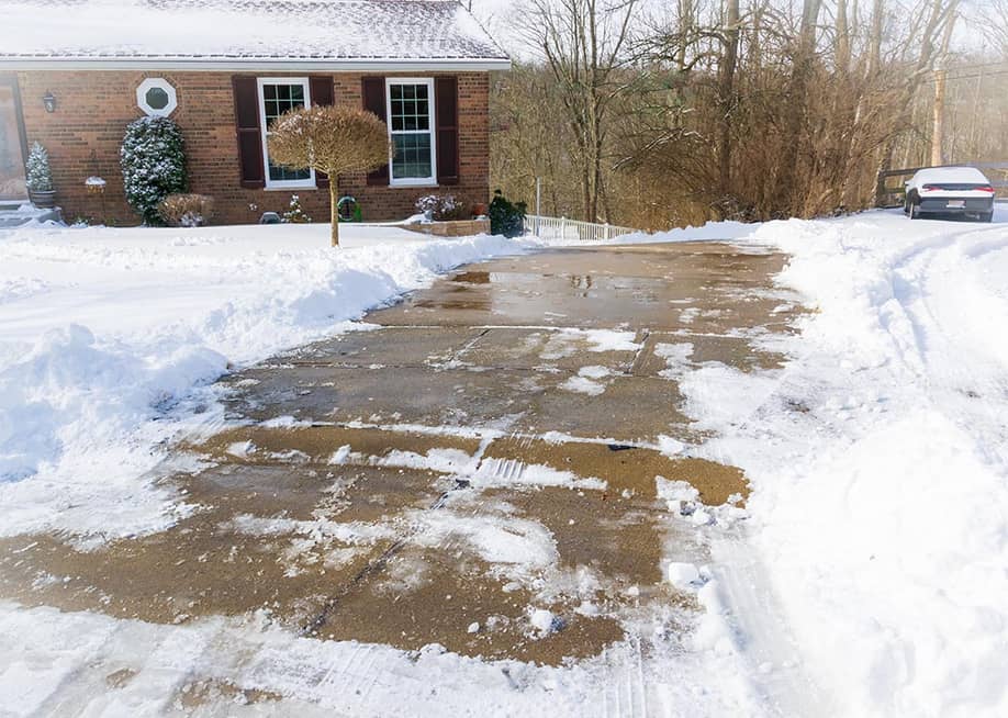 Long, steep, driveway in Kentucky after snow storm, all cleaned up with shoveling and salting. — RDNichols // Shutterstock