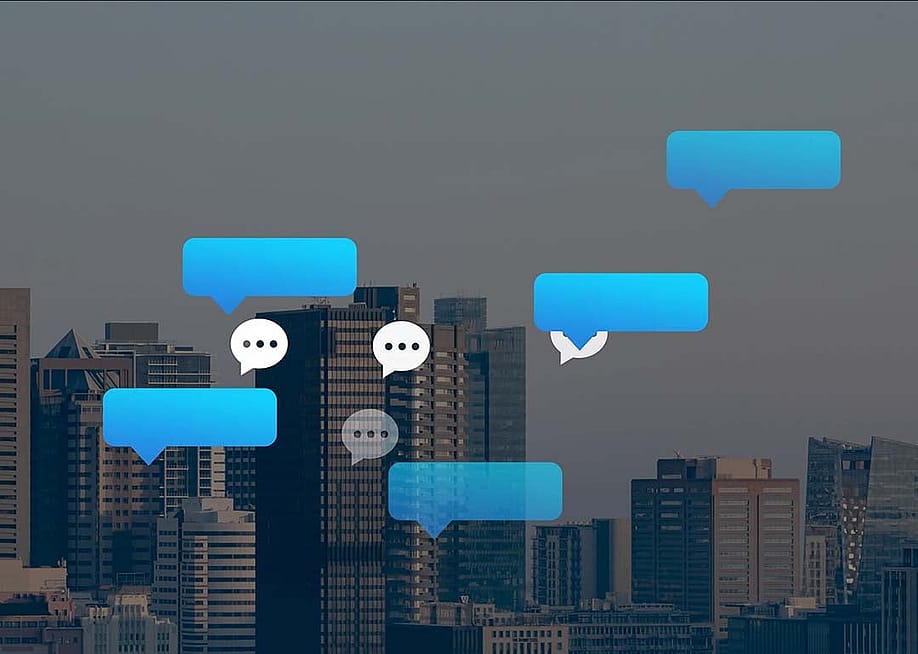 Vector chat and speech bubbles with a backdrop of city buildings. — vectorfusionart // Shutterstock