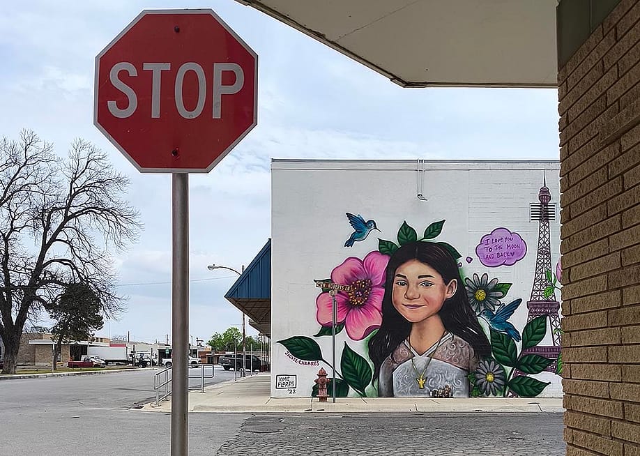 A murals of shooting victims in Uvalde painted on a wall behind a stop sign. — na Vargas