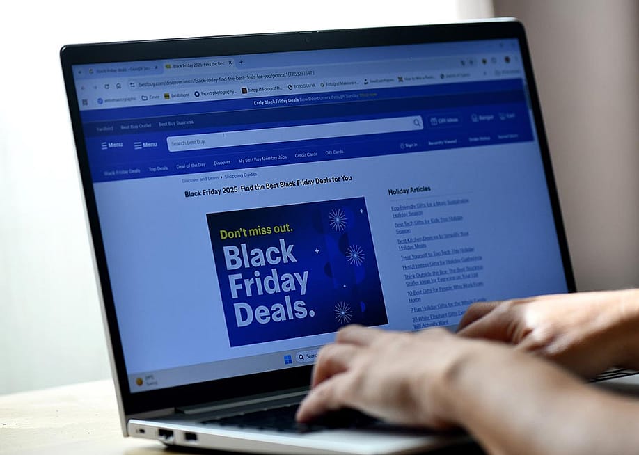 Hands typing on a laptop displaying a Black Friday Deals advertisement page. — Ibrahim Alkan // Shutterstock