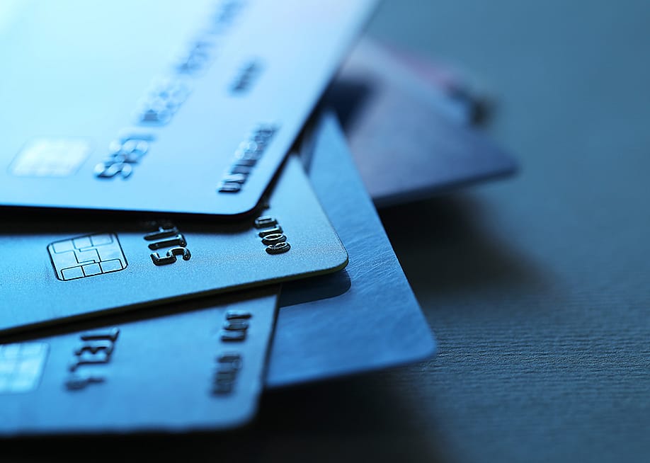 A stack of credit cards in dim light. — New Africa // Shutterstock