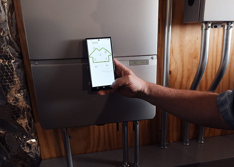 A homeowner using a phone monitoring a battery from Sunrun, a company which provides home solar and batteries. A new partnership between Sunrun, Ford and the Baltimore Gas and Electric Company has resulted in a residential vehicle to grid pilot project. — Sunrun