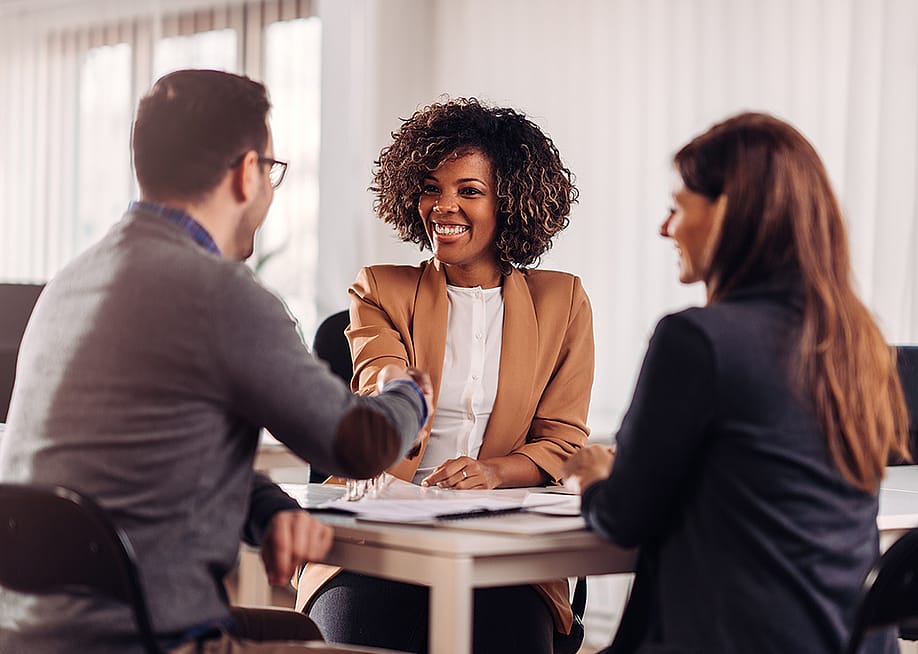 Business people shaking hands in a meeting. — Zivica Kerkez // Shutterstock
