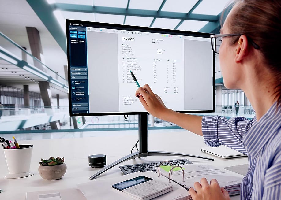 Person pointing out line item on invoice on large computer monitor. — Andrey_Popov // Shutterstock