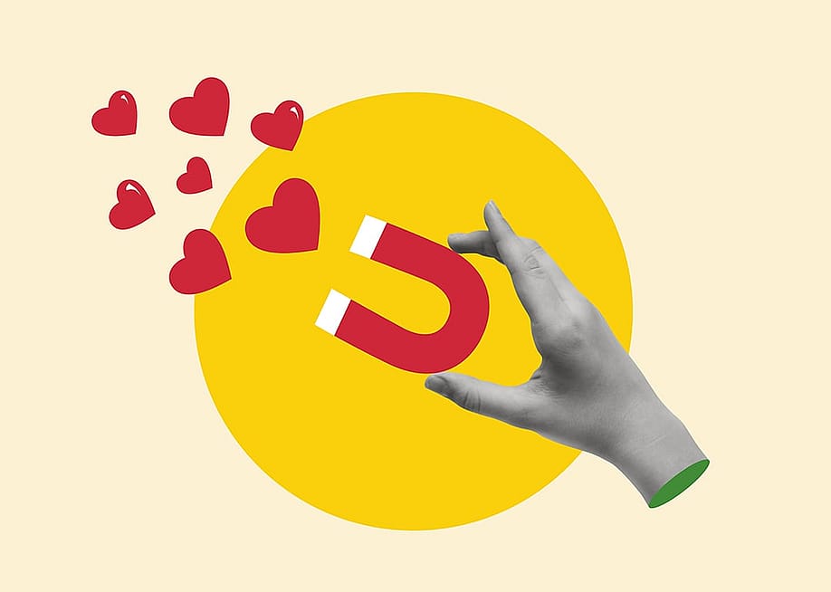 A custom illustration of a hand holding a magnet pulling hearts. — Elenyska // Shutterstock