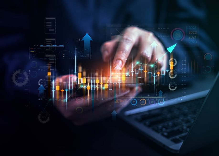 Stock market trading graphics illustrated over a businessperson using a phone and laptop. — 1st footage // Shutterstock