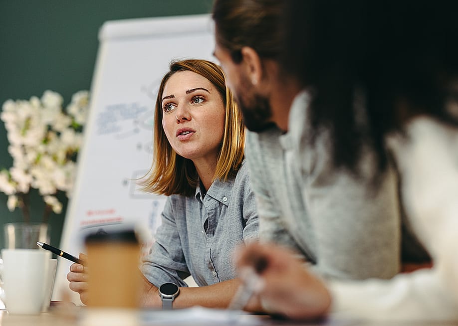 A young businesswoman in a meeting with her colleagues in a boardroom. — Jacob Lund // Shutterstock