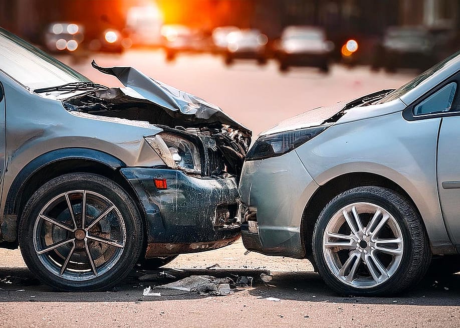 Side view of two silver cars that are stopped in a collision with the hood of one car visibly damaged. — Giama22 // Shutterstock