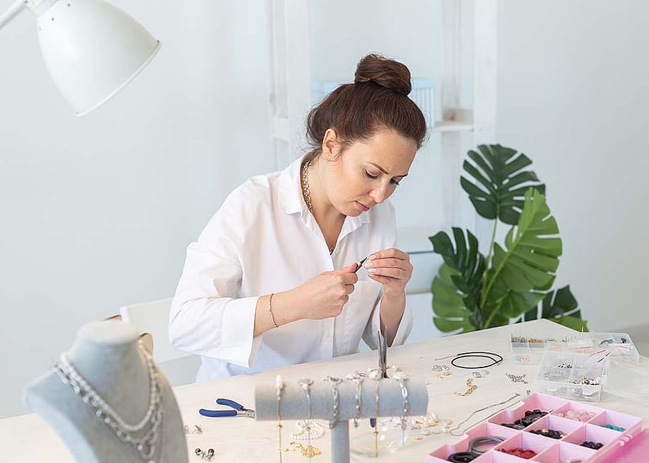 A female professional jewelry designer working on hand-made jewelry in her workshop. — Best smile studio // Shutterstock