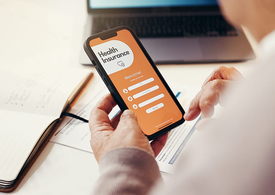 A senior person browsing a health insurance app on a smartphone. — PeopleImages // Shutterstock