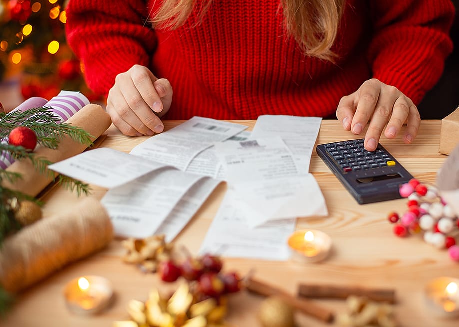 Person calculating expenses for the holidays. — Vitalii Stock // Shutterstock