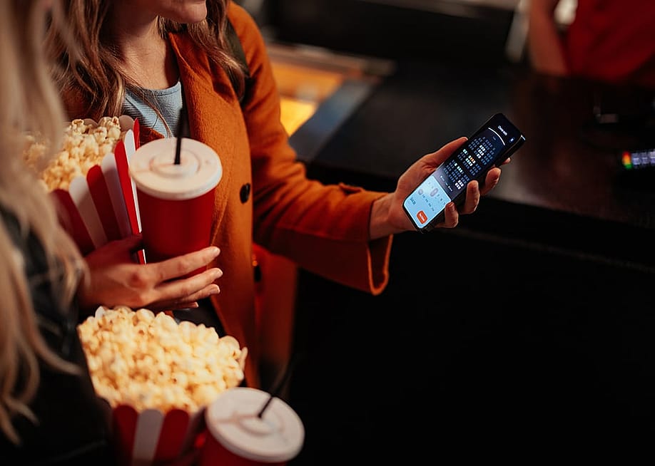 A young woman checking seats in a theater using a mobile app. — bbernard // Shutterstock