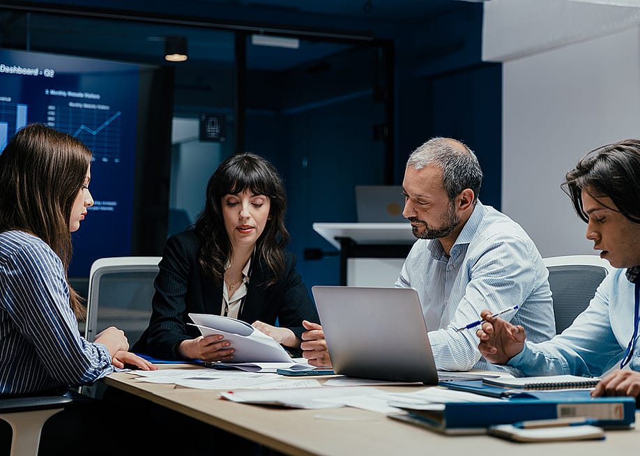 A group of business executives brainstorming in a boardroom. — Suteren Studio // Shutterstock