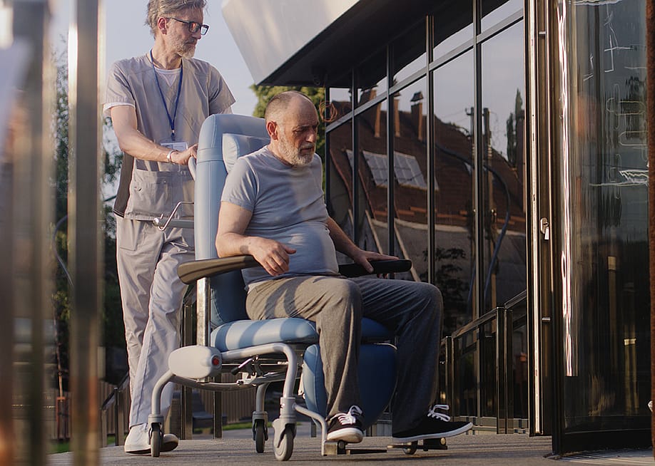 Two doctors assisting a disabled elderly man to the clinic entrance. — Frame Stock Footage // Shutterstock