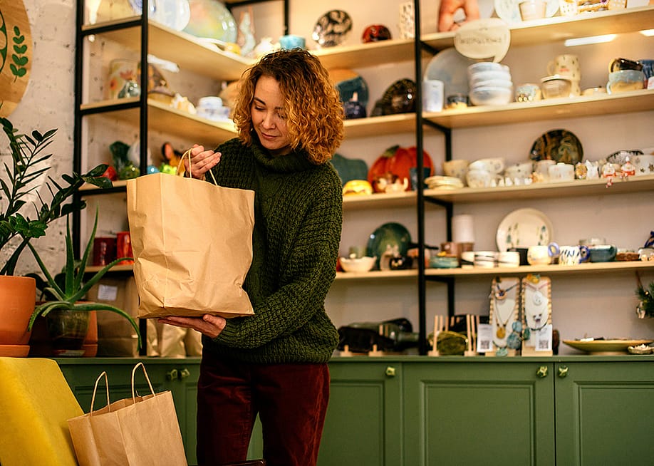 A woman packing sustainable gift items for Christmas. — IRA_EVVA // Shutterstock