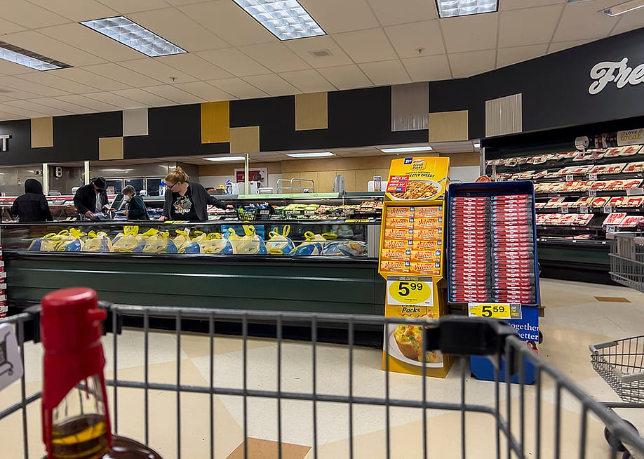 Wide view of people shopping for Butterball Thanksgiving turkeys inside a grocery store. — Colleen Michaels // Shutterstock