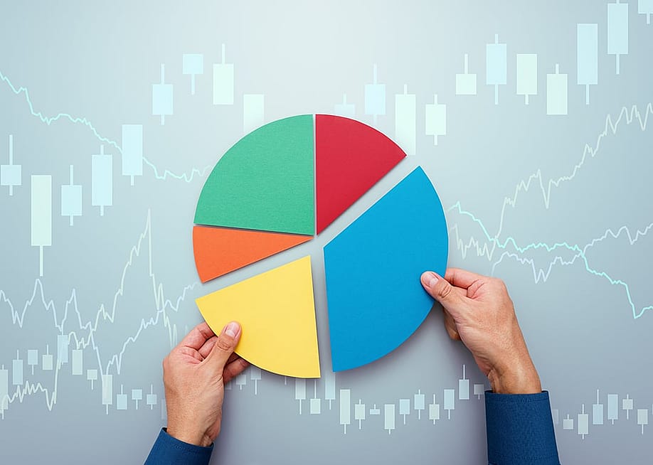 A person completing a pie chart with candlestick, investment charts graphics. — tadamichi // Shutterstock