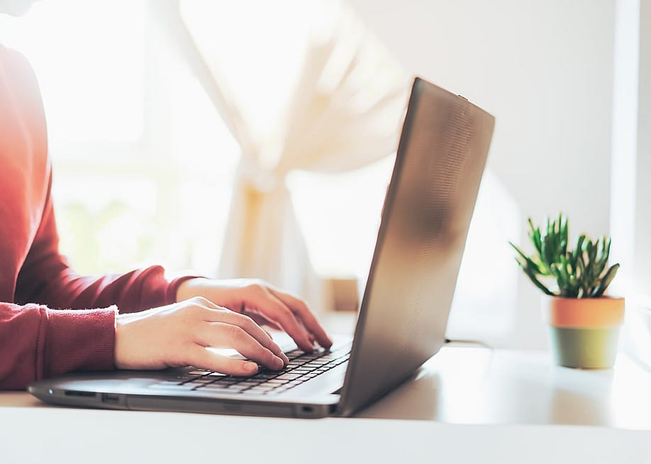 Person typing on a laptop. — Okrasiuk // Shutterstock