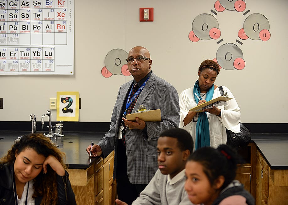 Godfrey Rangasammy, Supervisor of Science, background center, and Tanisha Johnson, a Science Coach, right, background, observe a chemistry class as Literacy coaches at Northwestern High School in Hyattsville, Maryland. — Astrid Riecken for The Washington Post via Getty Images