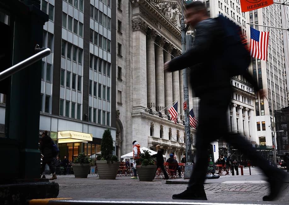 A blurred person in black clothing in the foreground walks past the New York Stock Exchange (NYSE) on November 20, 2025 in New York City. Stocks surged over 500 points after Nvidia on Wednesday reported fiscal third-quarter earnings that beat expectations. — Spencer Platt // Getty Images