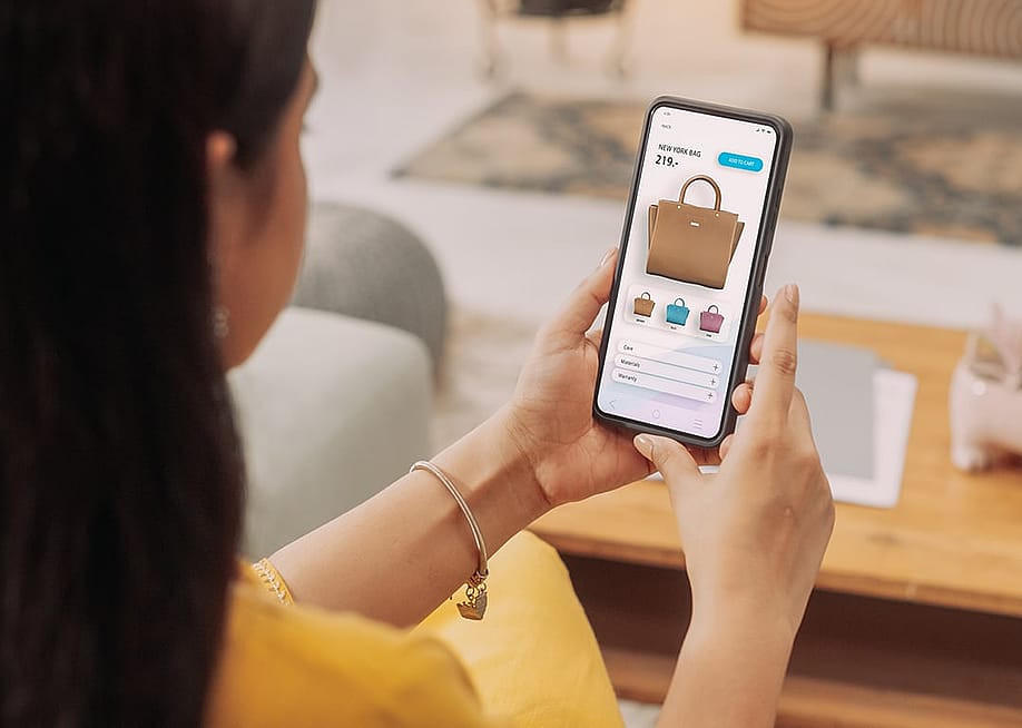 A woman browsing a shopping page on her smartphone. — Kitreel // Shutterstock