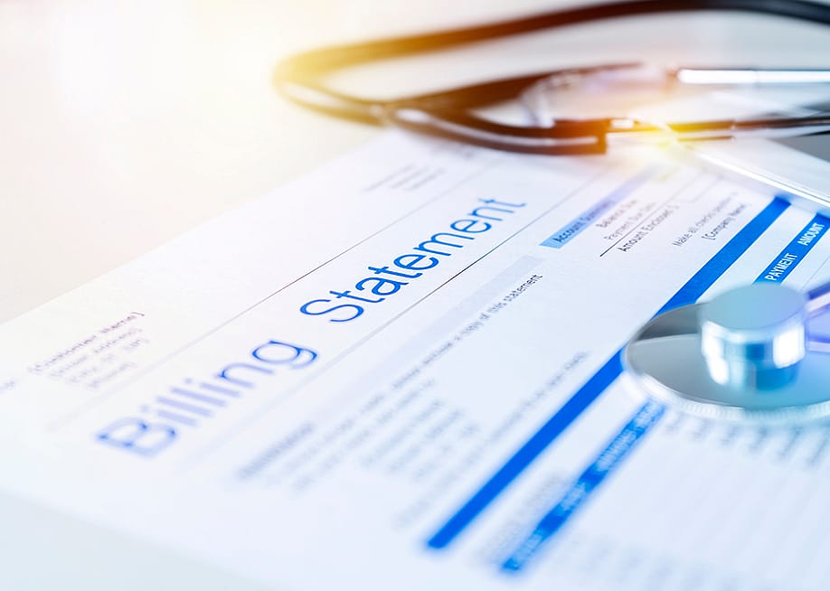 A close up on a healthcare billing statement document with a stethoscope on top. — jittawit21 // Shutterstock
