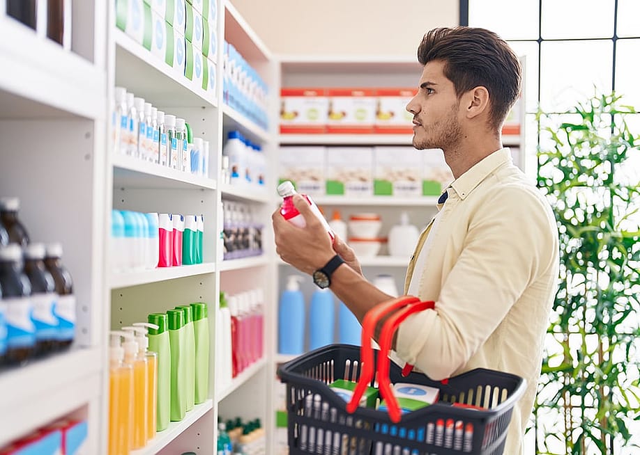 A man holding a basket and shopping at a pharmacy. — Krakenimages.com // Shutterstock