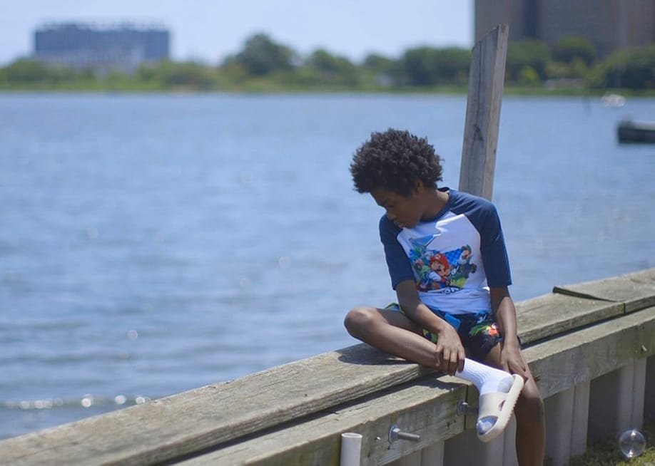 A boy looking out over Jamaica Bay in the Edgemere neighborhood of New York City. — Evan Simon // Floodlight