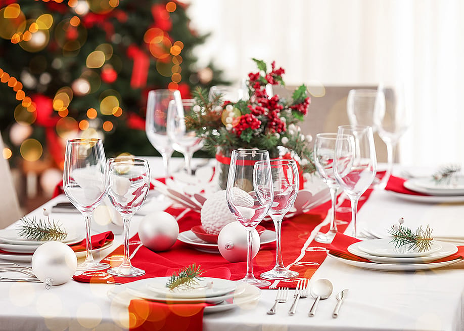 A beautiful Christmas dinner table setting with red and white motifs. — Pixel-Shot // Shutterstock