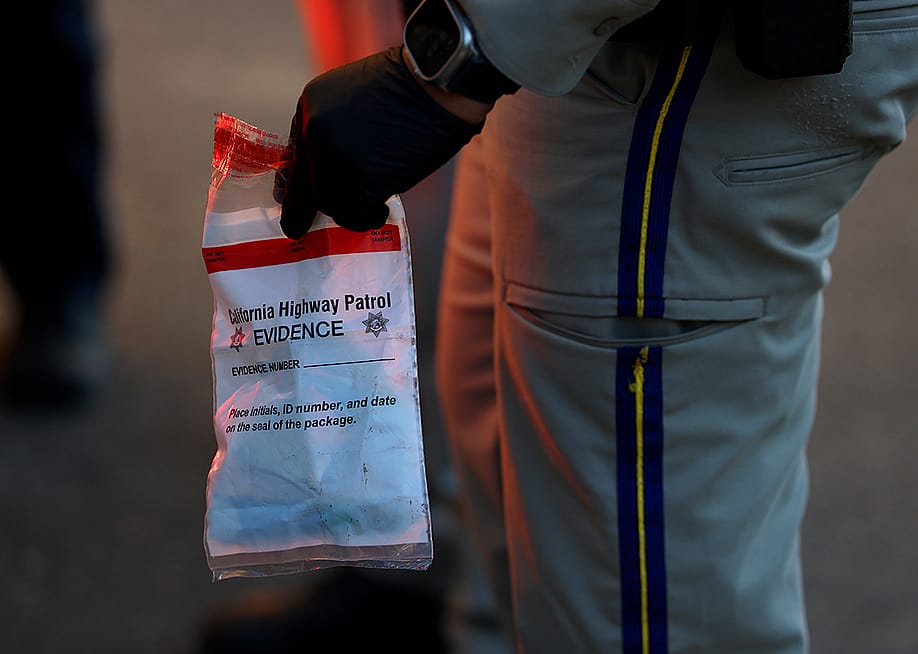 A California Highway Patrol officer holding an evidence bag after taking a suspect into custody. — Justin Sullivan // Getty Images