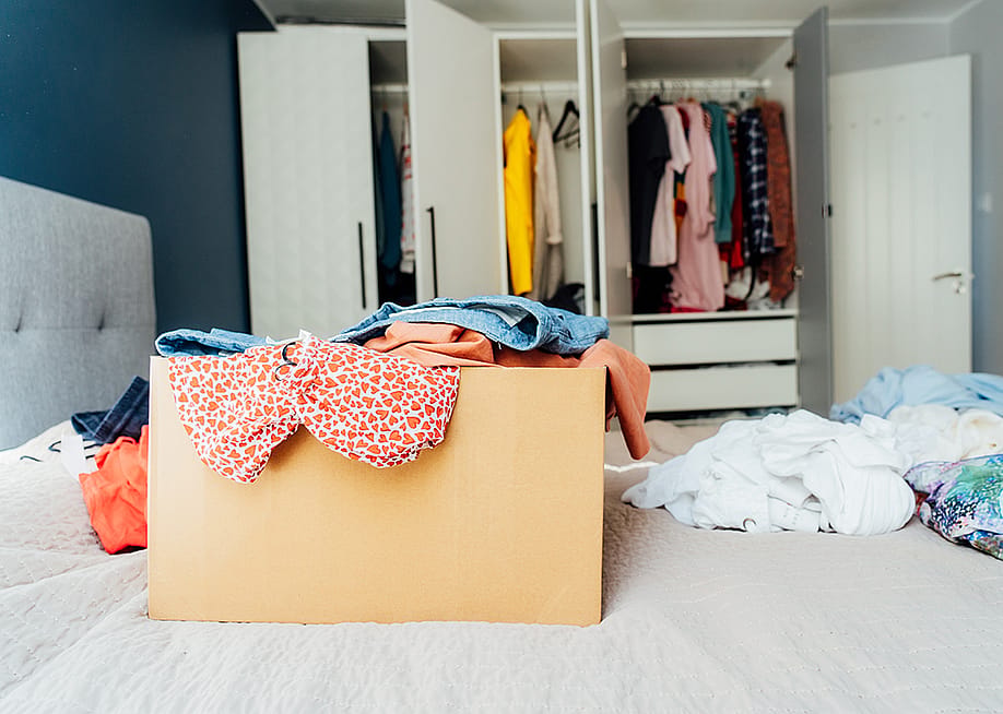 A box full of selected clothes from closet cleanup. — Okrasiuk // Shutterstock