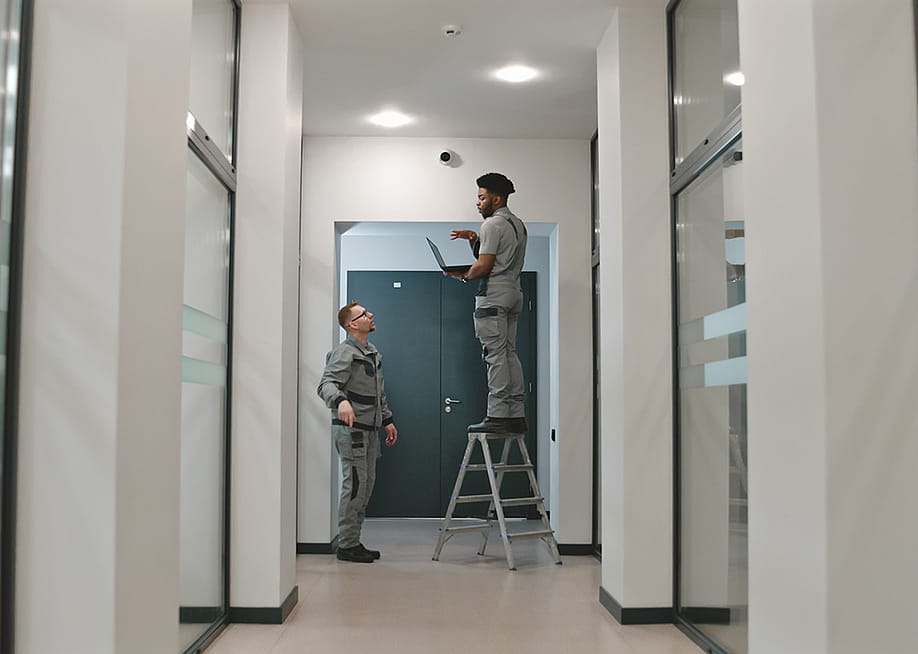 Two installation workers setting up a surveillance camera. — Frame Stock Footage // Shutterstock