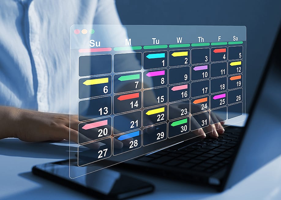 Person using a laptop with graphics of a digital calendar. — Miha Creative // Shutterstock