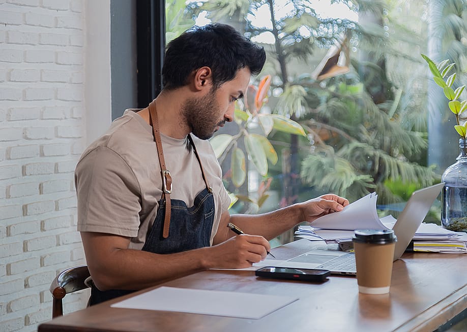 A small restaurant business owner working on tax documents. — Simplylove // Shutterstock