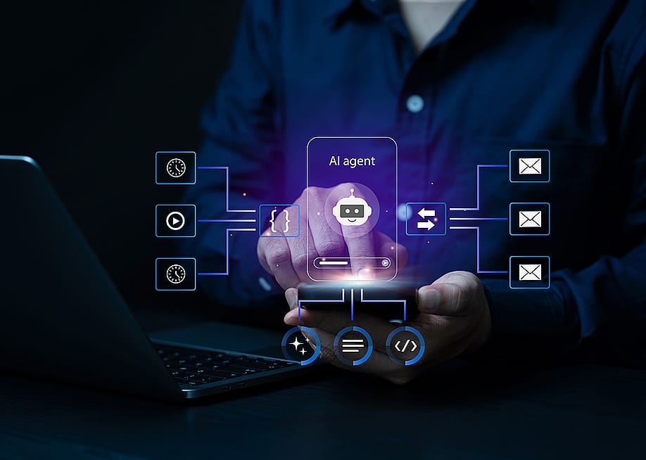 Person using a laptop and smartphone illustrated with AI agentic software graphics. — BOY ANTHONY // Shutterstock