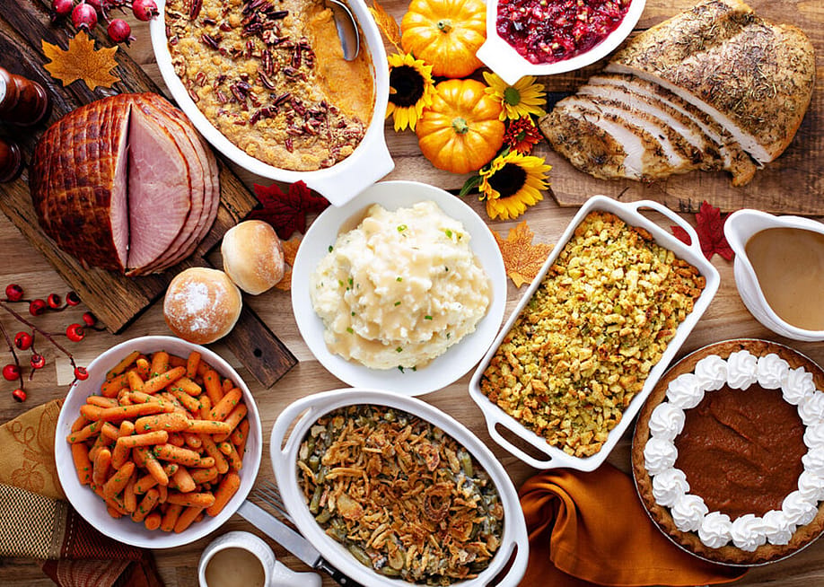 A table full of traditional holiday and Thanksgiving dishes such as mashed potato, ham, turkey, stuffing, and pumpkin pie. — Tyson Foods