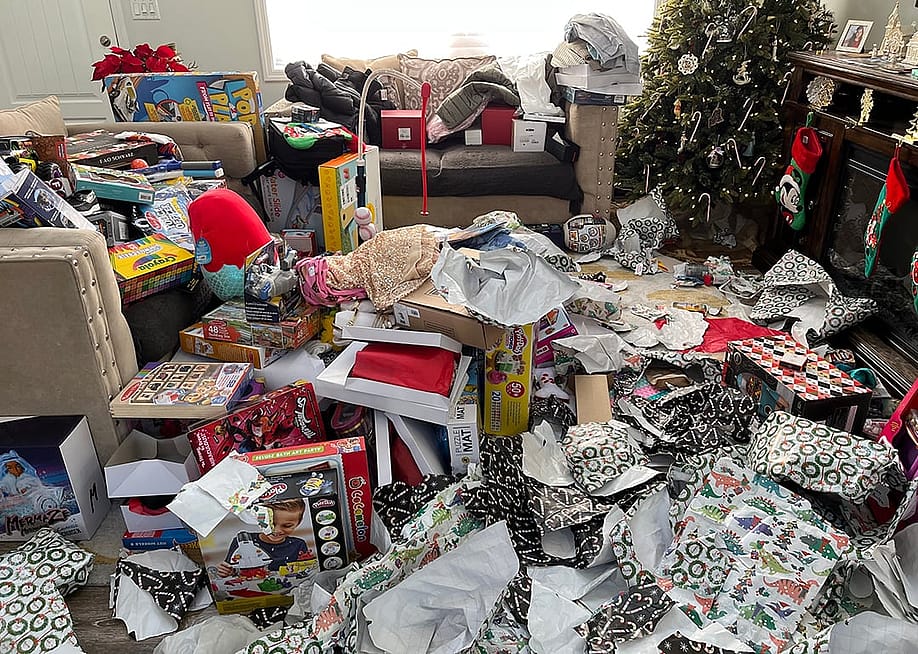 Piles of messy packaging and opened presents in a living room during Christmas morning. — Jaclyn Vernace // Shutterstock
