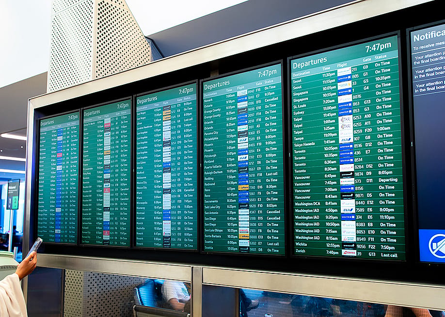 A flight arrival and departure board at an airport. — bluestork // Shutterstock
