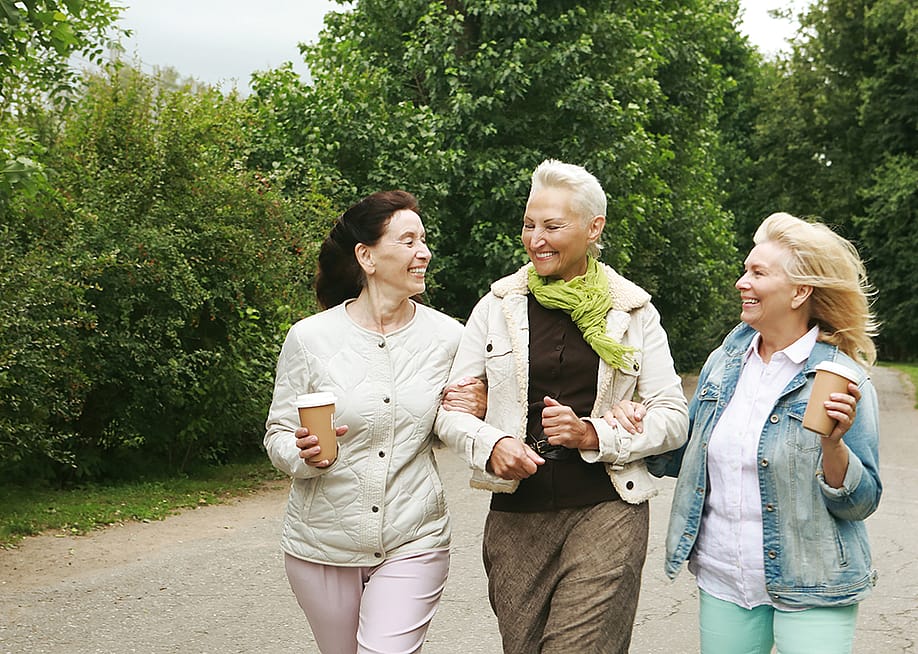 Three elderly women walking in the park. — Raisa Kanareva // Shutterstock
