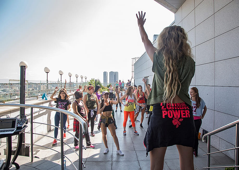 A group having a Zumba party at the top floor of a hotel. — Maffi // Shutterstock