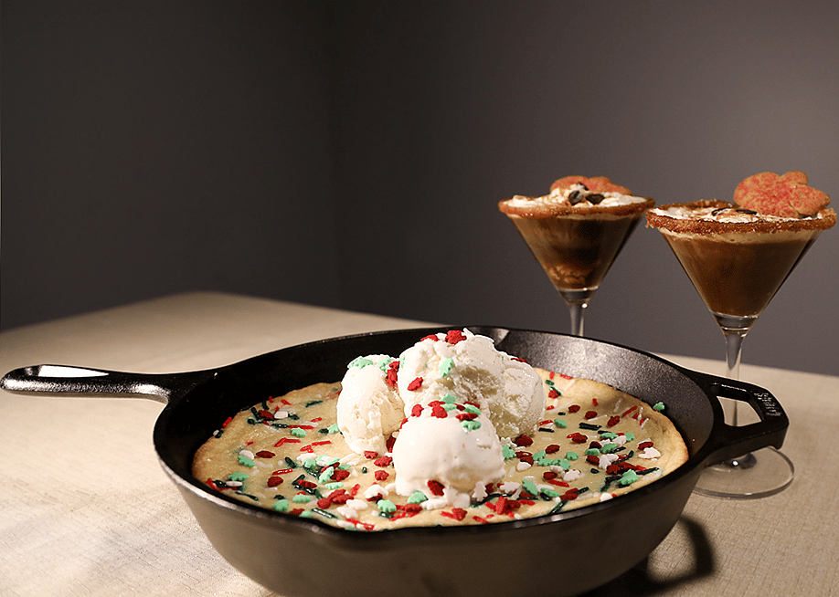 A 'Winter Wonderland' Sugar Cookie on a skillet with two glasses of Gingerbread Espresso Martini. — Wildfire Outdoor Living