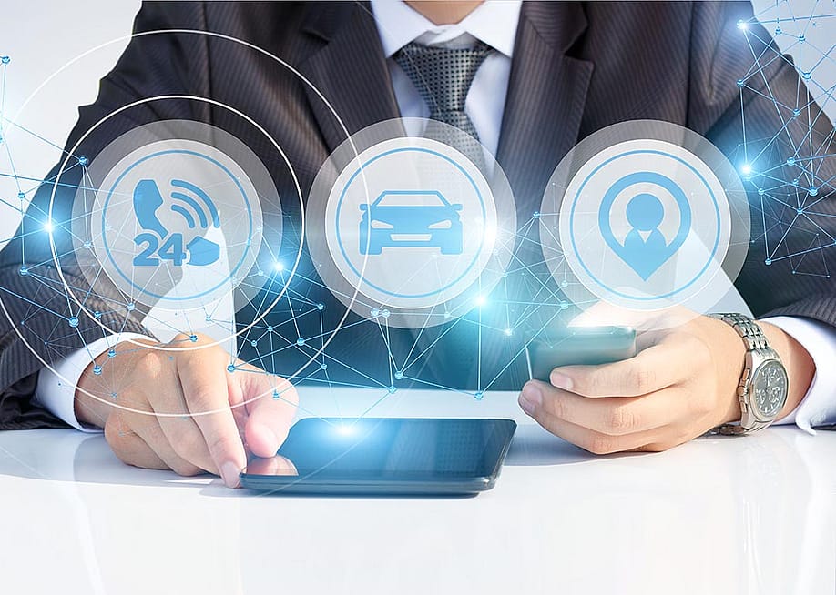 Person wearing business suit and fancy watching with face not showing looking at tablet and smartphone, with icons of cars, 24 hour phone service and agent superimposed symbolizing AI services. — Natali _ Mis // Shutterstock