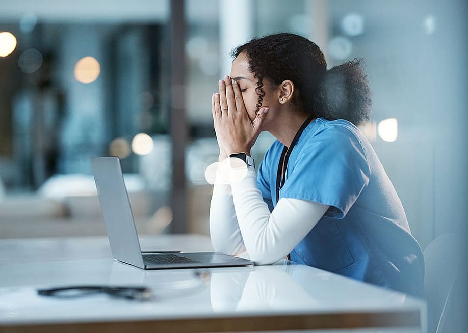 A hospital nurse experiencing burnout at work. — PeopleImages // Shutterstock